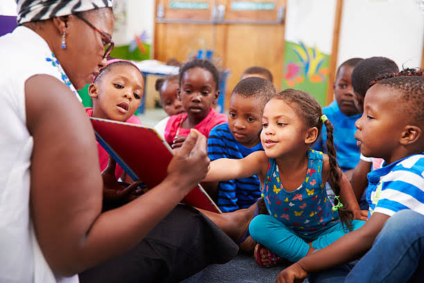 Black teacher with black kids in a school 