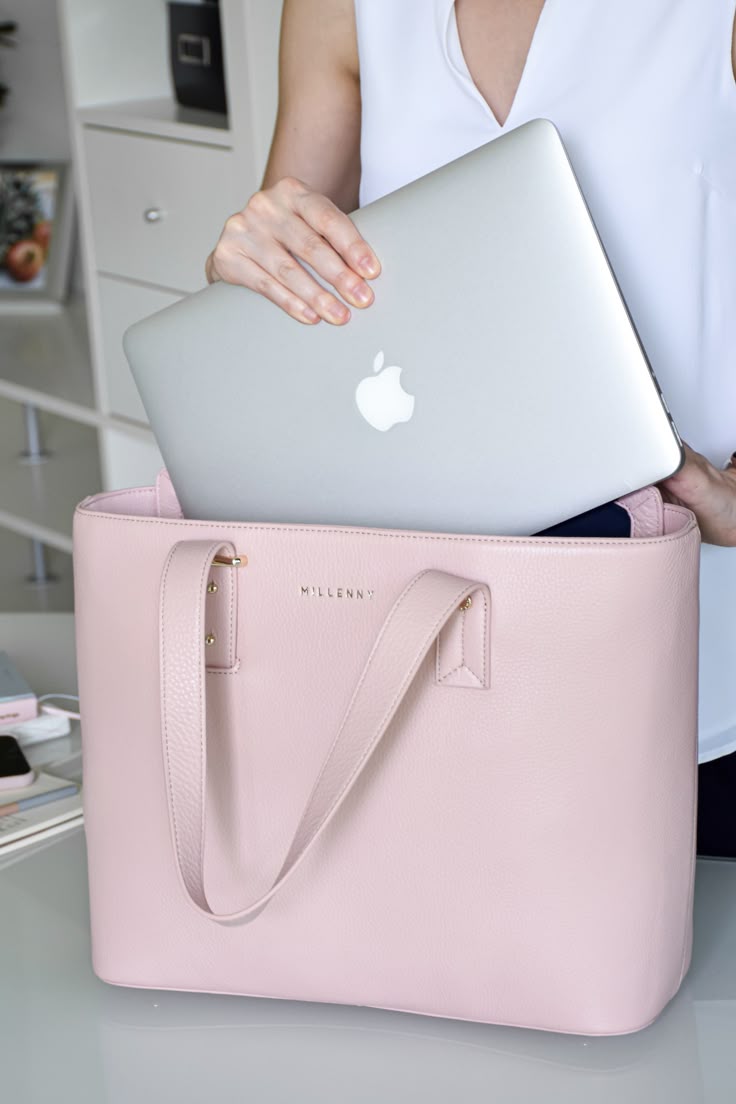 woman removing her mac book from her pink bag