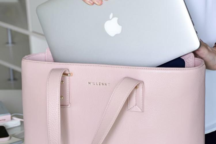 woman removing her mac book from her pink bag