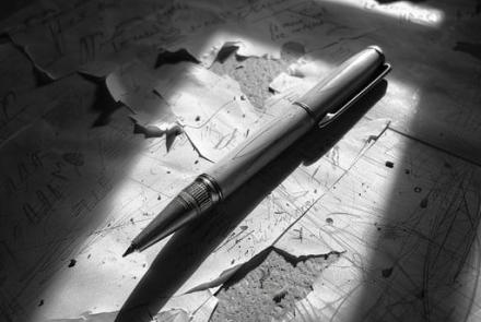 Torn pieces from a letter with a pen